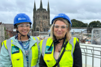 Cllr Nova Arkney (left) and Cllr Carol Dean (right) in high vis jackets and blue helmets on top of a building site