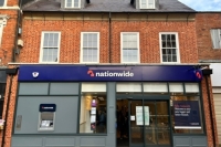 A front view of the new nationwide building. A brick building with the purple nationwide logo across the middle of the building